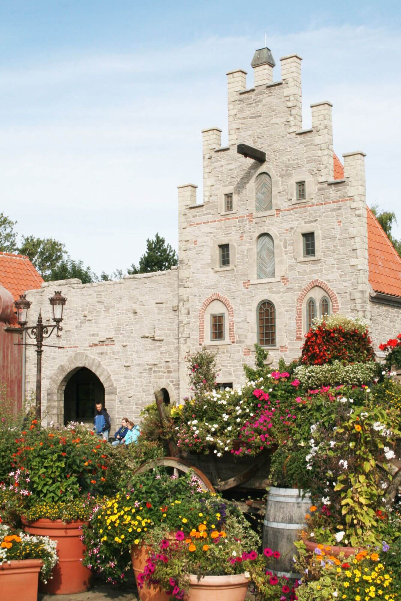 Die hanseatischen Arcaden. Im Fokus ist die alte Apotheke. Davor steht ein Karren mit Blumen.