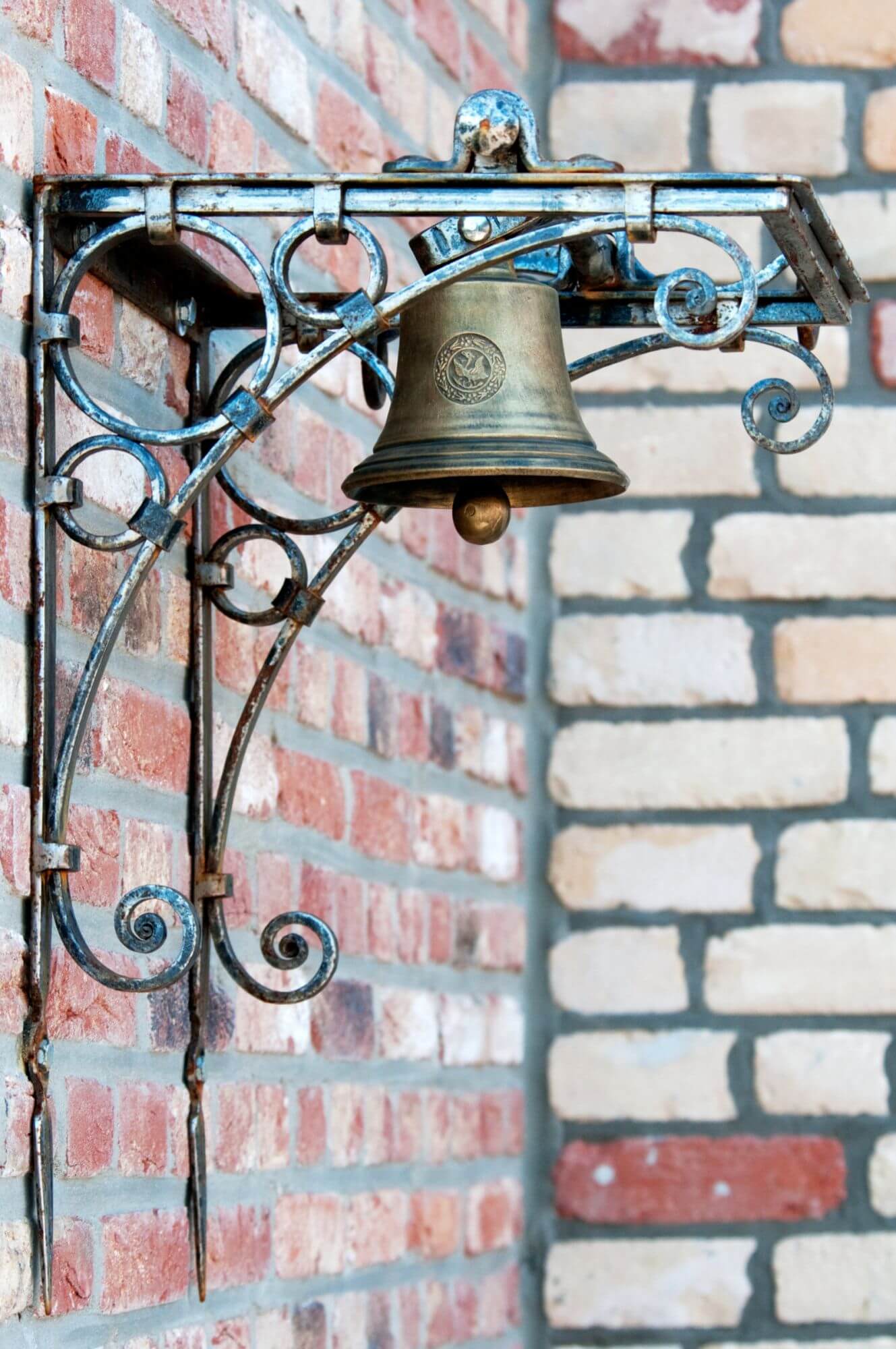 An der Wand der Arcaden aus Brügge befindet sich eine Glocke.
