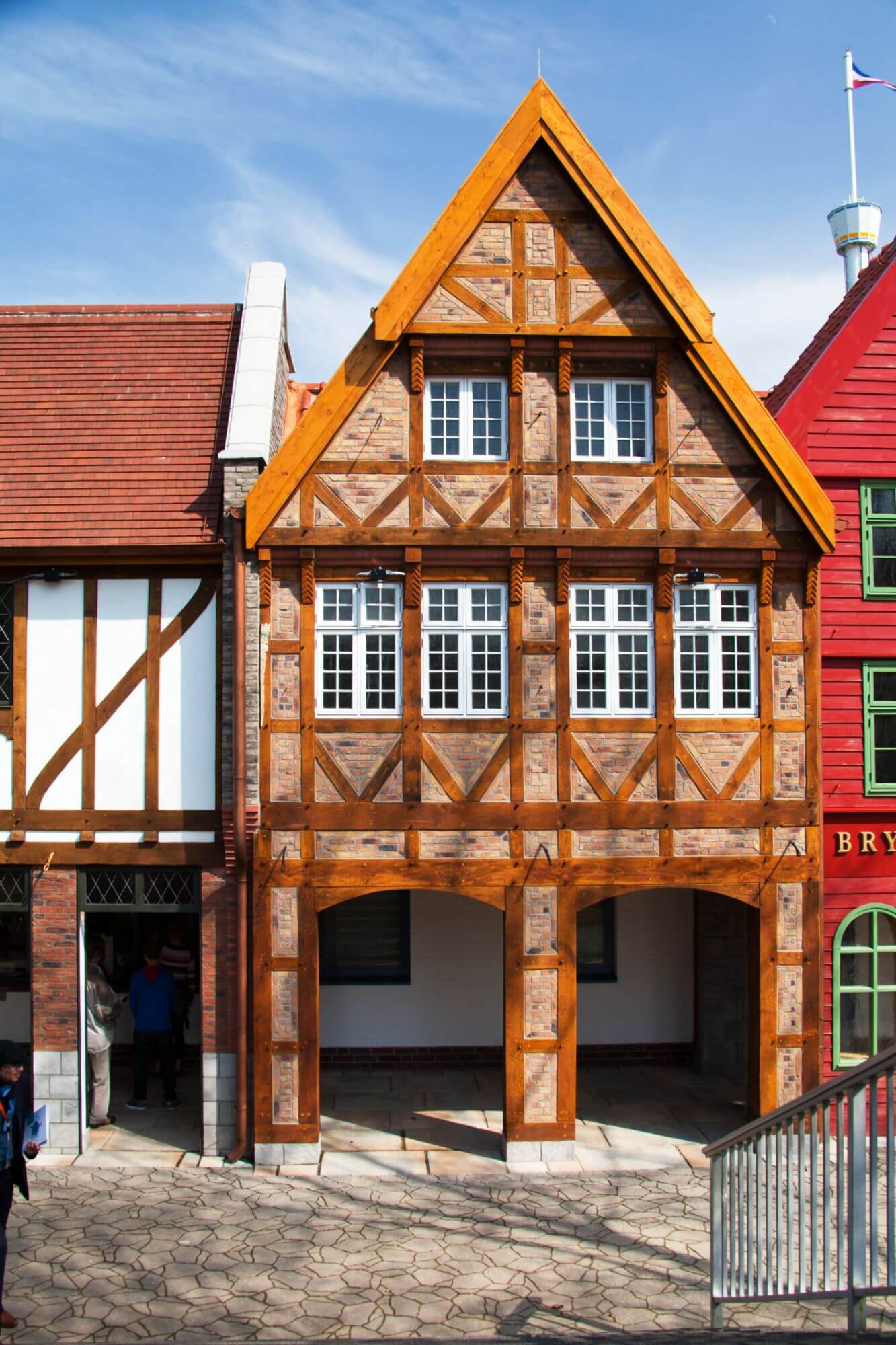 Blick auf die Arkaden des Vorplatzes. Das Gebäude ist im Fachwerkstil mit weißen Fenstern.