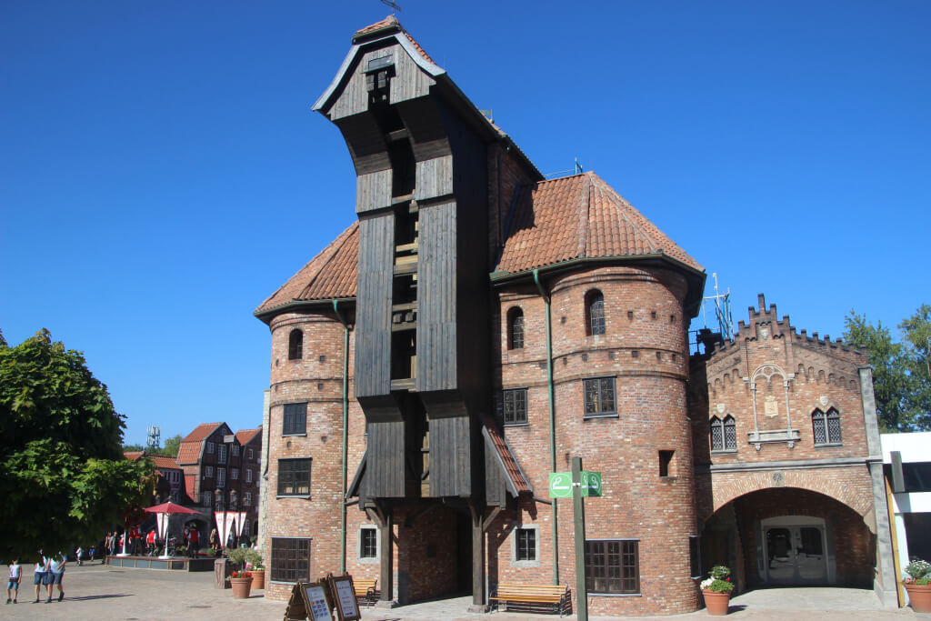 Das Krantor von Danzig von vorne. Davor sind Schilder und ein Schild für eine Raucherinsel.