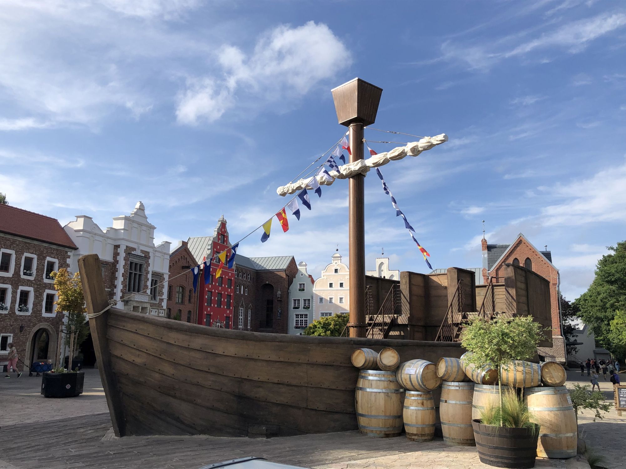 Die HANSE-Kogge von der Seite. Neben der HANSE-Kogge sind Fässer.