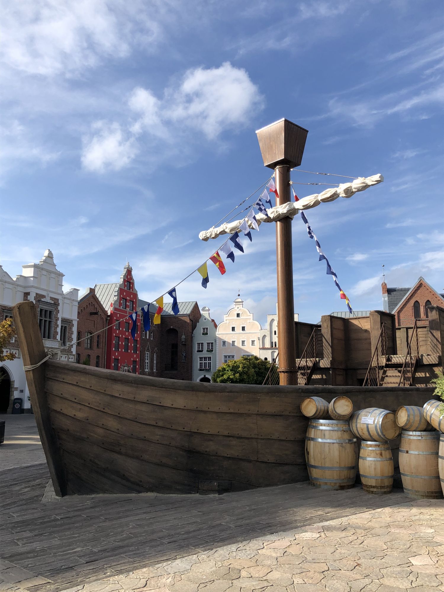 Die HANSE-Kogge von der Seite. Neben der HANSE-Kogge sind Fässer.