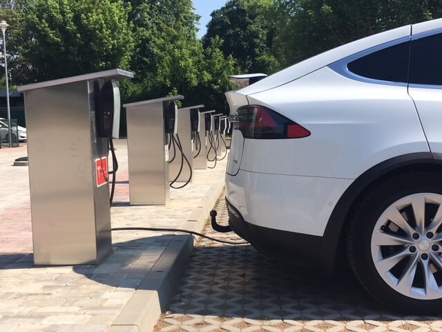 An der Ladesäule ist ein E-Auto angeschlossen. Dieses wird über ein Kabel geladen.