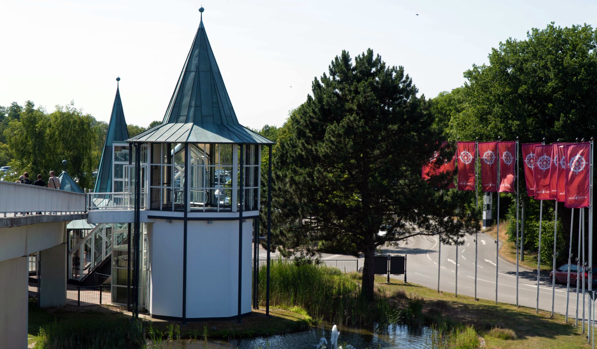 Im Vordergrund befindet sich der Rolltreppenturm. Vom HANSA-PARK-Großparkplatz fährt ein PKW runter.