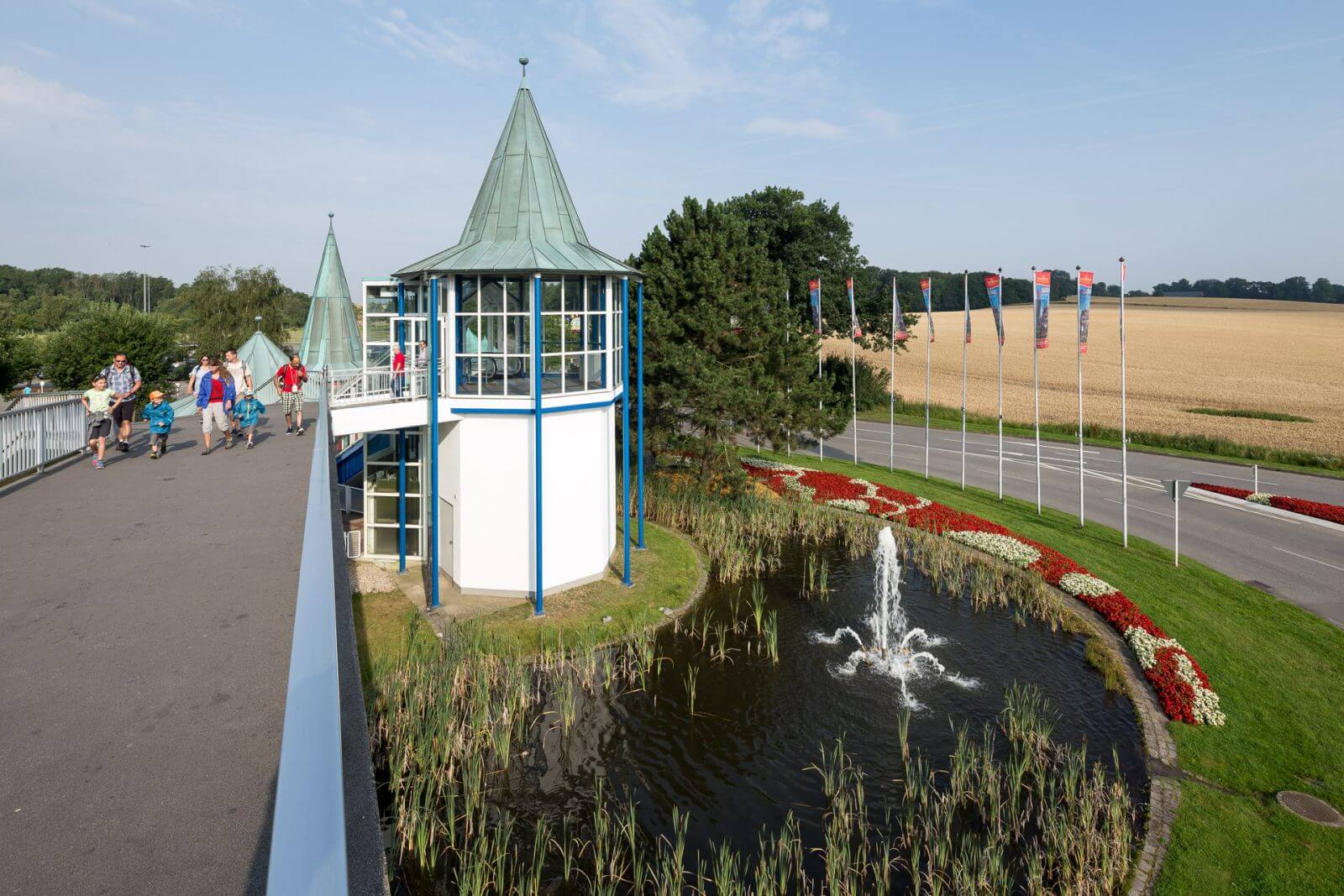 Auf der Brücke sind Gäste auf den WEg zum HANSA-PARK. Sie kommen vom HANSA-PARK-Großparkplatz.