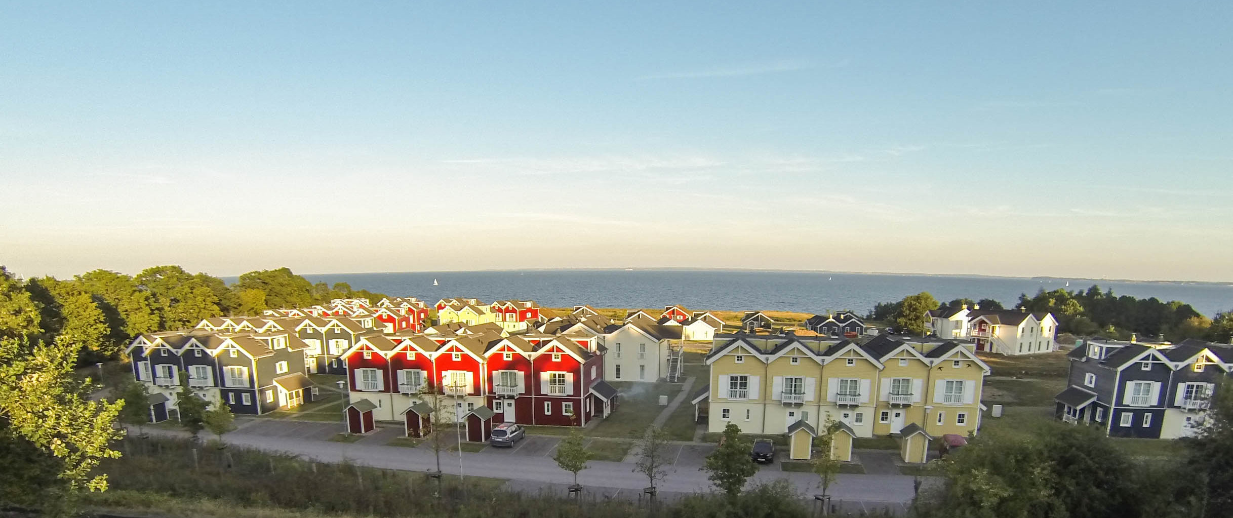 Viele kleine sich ähnlich sehende Häuschen. Dahinter die Ostsee.