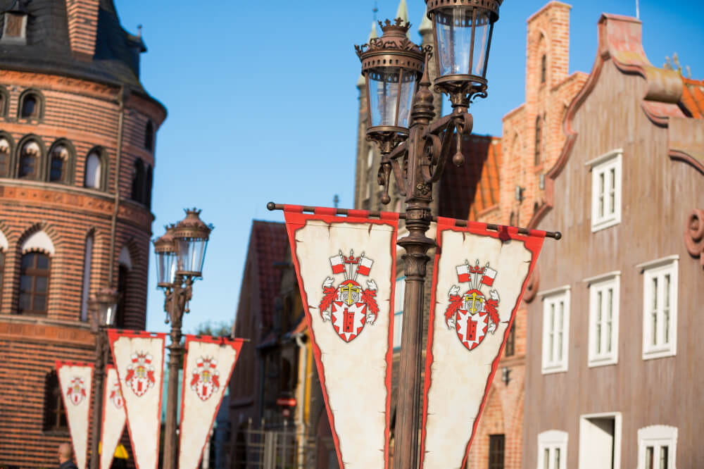 Die Laternen tragen Wimpel mit dem HANSA-PARK-Wappen. Im Hintergrund hanseatische Arkaden.